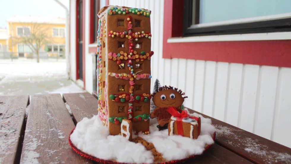 Pepparkakshöghusets 5 våningar har i veckan dekorerats av barnen på Ellen Keys förskola. Bredvid huset står Alfons Åberg, några granar och en julklapp.