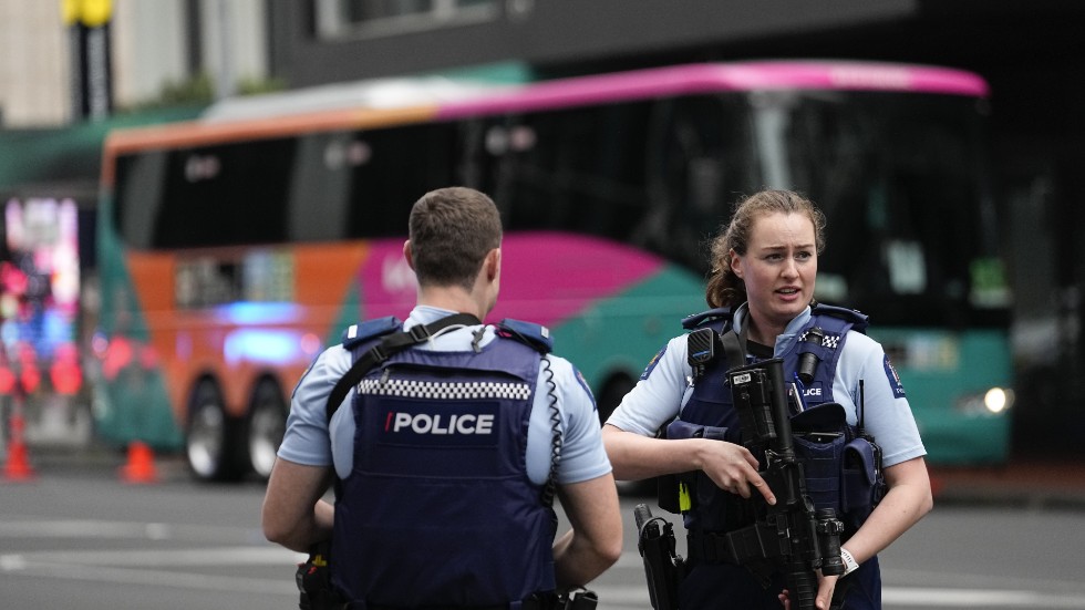 Beväpnad polis utanför ett av VM-hotellen i Auckland efter skjutningen där minst tre personer dödades.