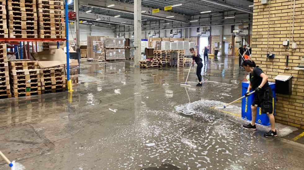 Det kraftiga regnet under natten mot lördagen gjorde att betonggolvet hos Packoplock fylldes med vatten. Personalen ryckte in för att raka undan vattenmassorna med gummiskrapor.
