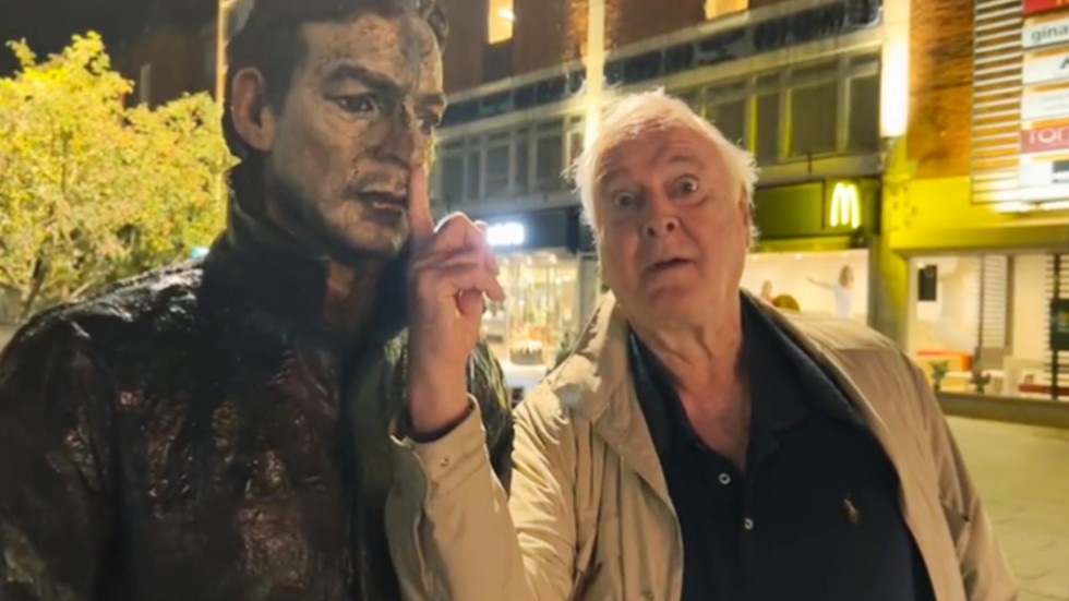 Bild från John Cleeses Twitter där han skojar med en staty i Umeå.