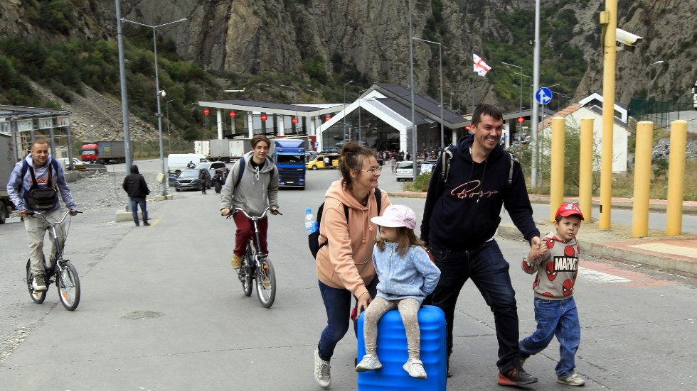 En ung familj och två cyklister korsar den ryska gränsen, kallad Verkhnii Lars, för att ta sig till Georgien.