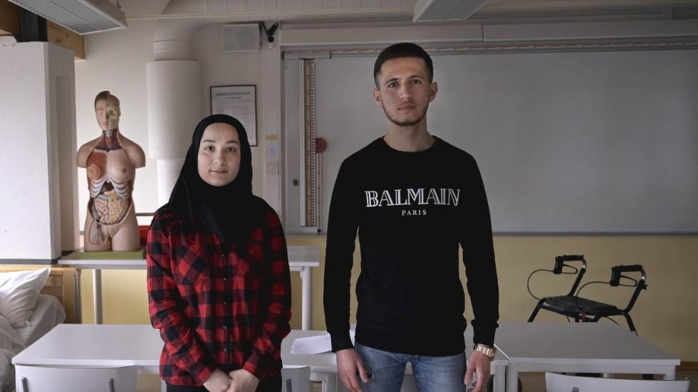 Vård- och omsorgseleverna Marva Abdul Hakim och Barez Hemn Jamal på högst tillfälligt besök i Arlandagymnasiets lokaler. Coronapandemin har lett till att de varvar jobb på äldreboende med studier hemma.